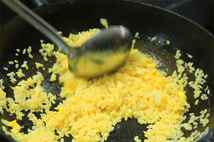 大火加熱炒鍋，再入油，燒到四至五成熱時倒入雞蛋液，在未凝結(jié)之前，加米飯煸炒，不停翻炒并用鍋鏟將成塊的米飯碾開、撥散。