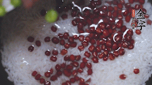 將炒好的食材和大米、紅豆一起放進(jìn)電飯鍋煮。