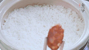 煮開后轉(zhuǎn)小火，當米飯出現(xiàn)小孔時，鋪上金字麻辣香腸。