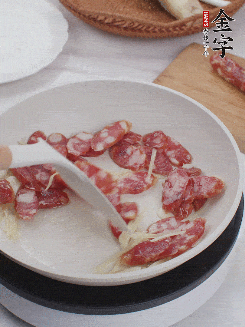 油溫3成熱時，下姜絲、蒜片、香腸炒出油脂。