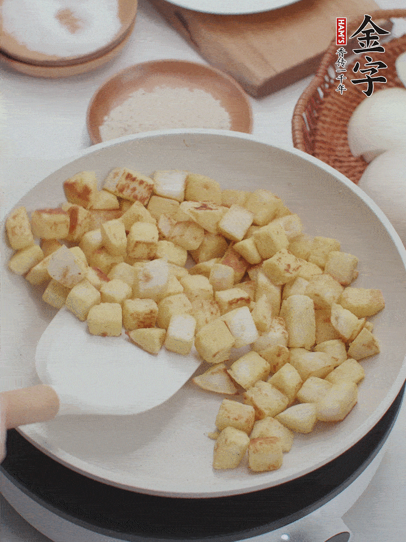 起鍋熱油，倒入饅頭丁，小火煎至蛋液凝固定型再翻面，饅頭丁部煎至金黃時盛起待用。