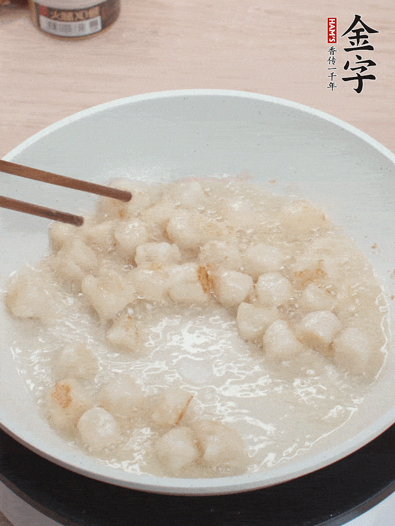 油溫4成熱，鮮貝蘸干淀粉下鍋煎，一面微黃后翻面。