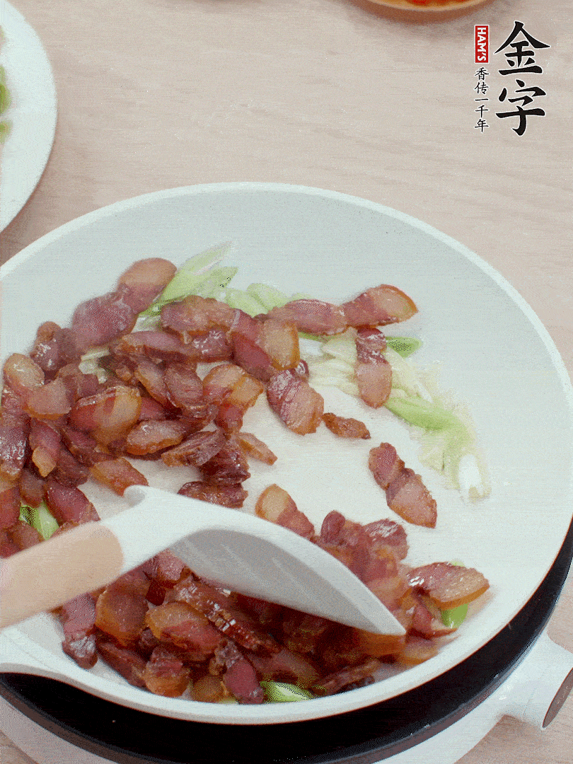 鍋中少許油，姜、蒜白爆香，下臘肉煸出油脂。