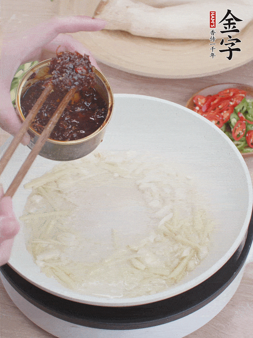 起鍋熱油，姜蒜、金字火腿干貝醬煸香。