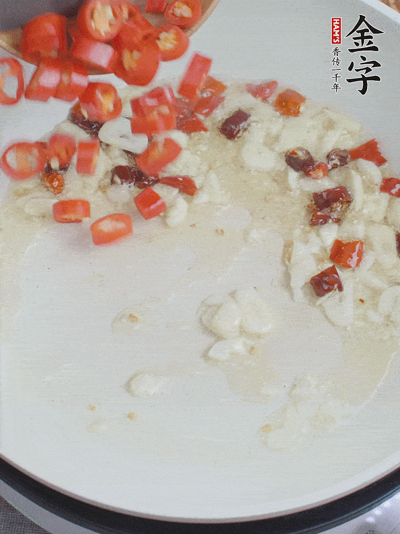 油6成熱，下蒜末、干紅辣椒煸炒，出香味后再放美人椒、香腸。