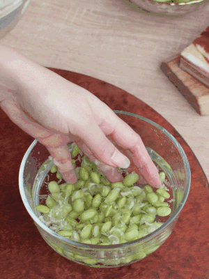 青豆剝殼，搓去外衣。