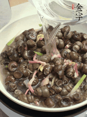 倒處理干凈的螺螄翻炒，加3勺料酒。加清水蓋過(guò)螺螄，中火蓋蓋煮5分鐘。