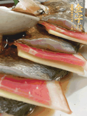 魚肚中塞蔥結(jié)、火腿片，魚身上碼放姜片、火腿片，倒入混合的料汁。