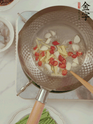 油7成熱時(shí)，下大蒜粒、姜絲、小米辣煸香。