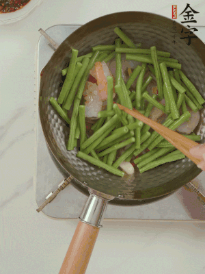 下掰好的缸豆段翻炒，略燜煮。