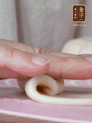 做面劑 油皮按扁，中間包入一個油酥，邊緣收緊捏死。包好的面劑按扁，用搟面杖搟壓成橢圓形。從底部向上卷成筒狀，用保鮮膜蓋好松弛15分鐘，再把筒狀縱向搟壓成長條狀。再卷一次，松弛20分鐘