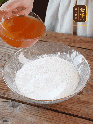 轉(zhuǎn)化糖漿、枧水、花生油攪拌均勻，加入面粉混合，醒發(fā)2小時(shí)。捏成23g一個的小球