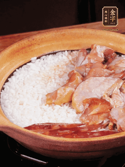 煮到椰子水微微收干轉(zhuǎn)小火，快速均勻鋪上雞肉、金字香腸