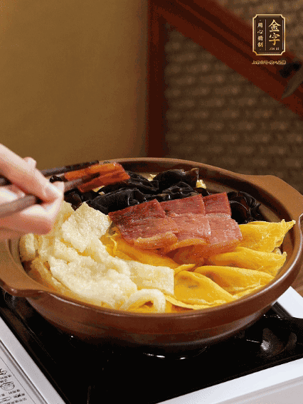 砂鍋底部鋪上娃娃菜，依次擺上肉皮、蛋餃、黑木耳、火腿